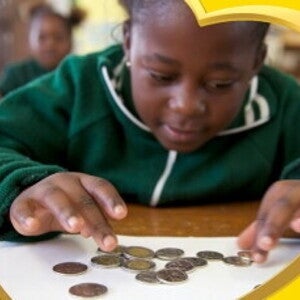 The child is counting coins