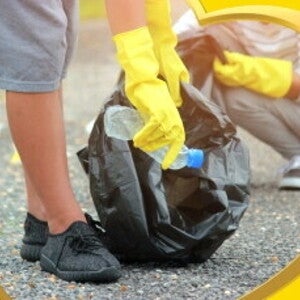 2 teenagers picking up plastics on a road