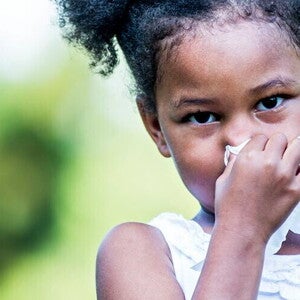 A girl blowing her nose