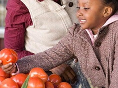 A-Z OF KIDS HEALTH AND NUTRITION A girl helping her mom choosing fruits and vegetables.
