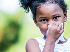 A girl blowing her nose
